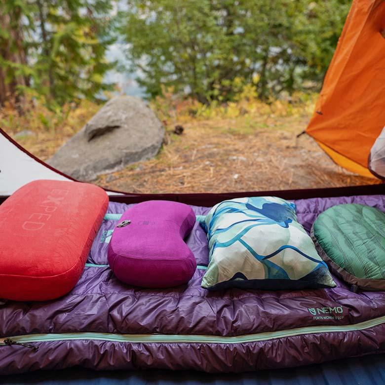Camping and backpacking pillows (lined up on sleeping bag in tent)